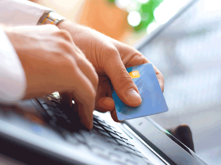Person using credit card to make a payment on a laptop